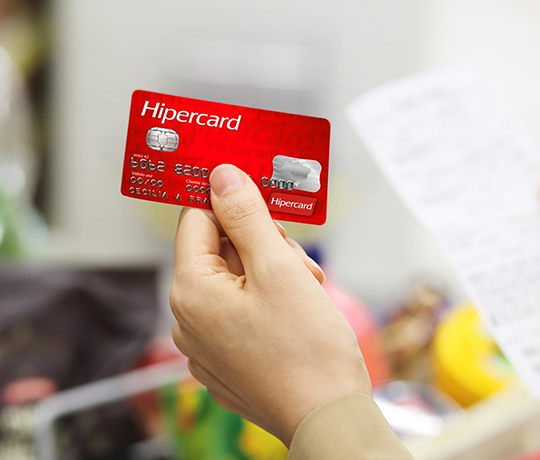 Mão segundo um cartão de crédito Hipercard