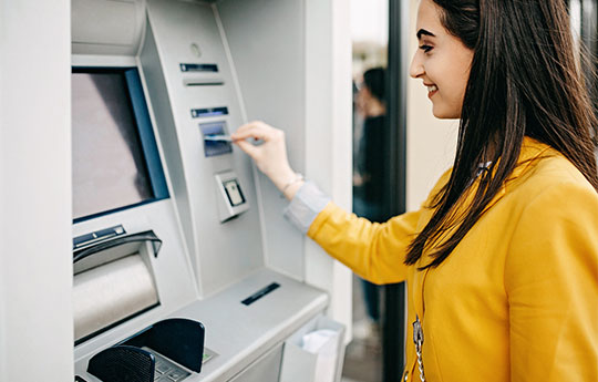 mulher retirando dinheiro em um atm